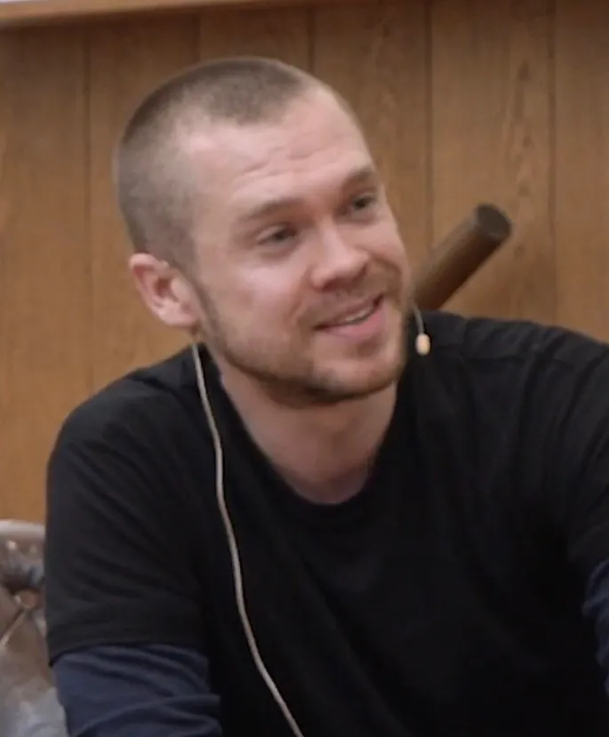 Gary Stevenson, close-cropped hair and a lapel mic, mid-sentence during an interview.